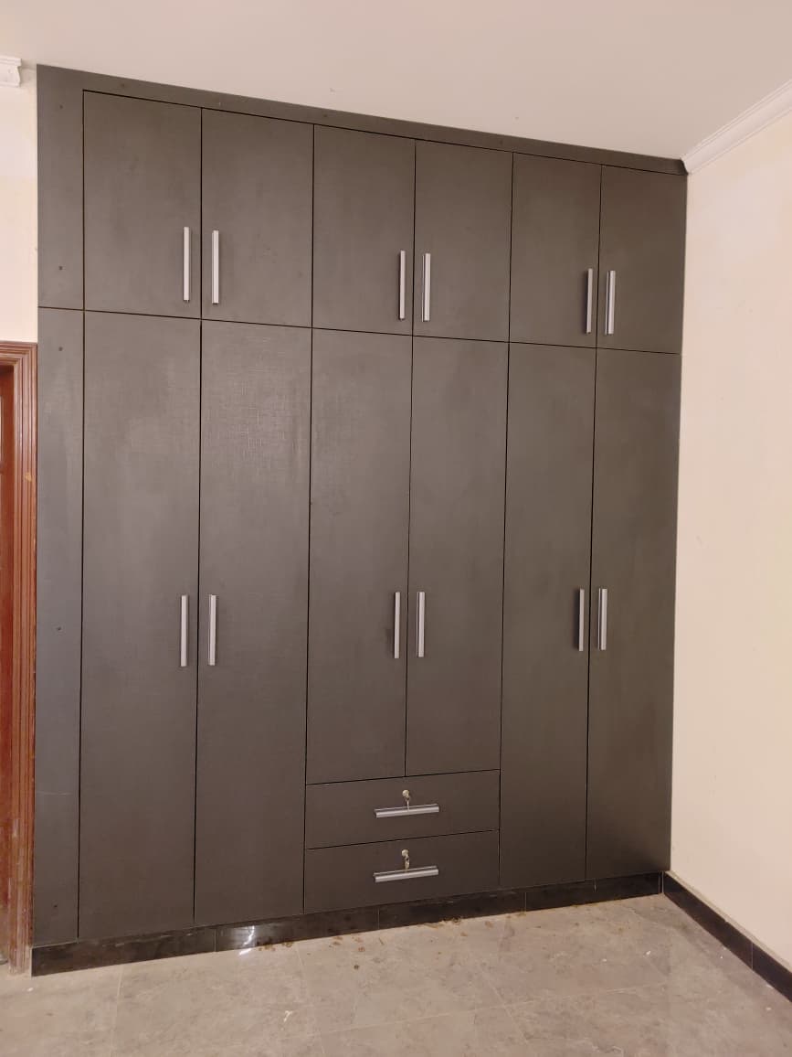 Floor-to-ceiling wardrobe with bar handles and lockable drawers