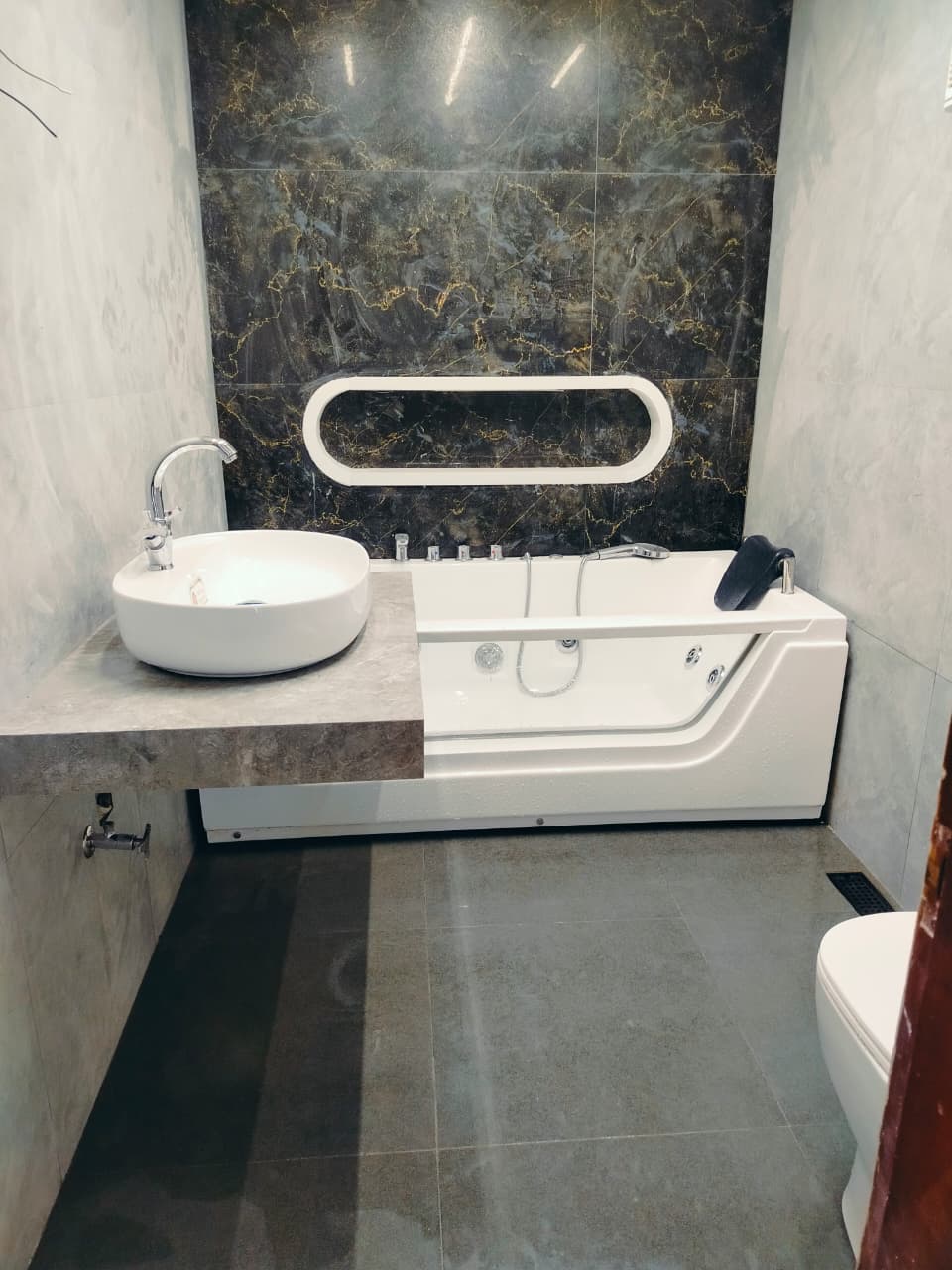Whirlpool bath set against a gold-veined marble wall