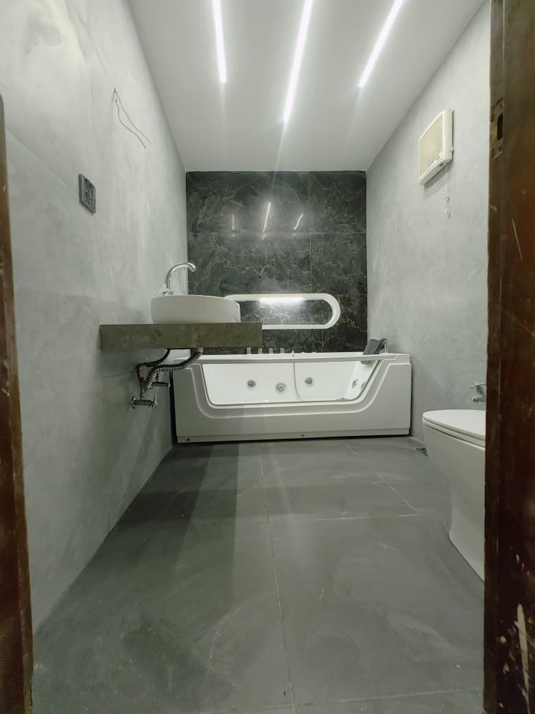 Bathroom with a whirlpool bath, vessel basin and linear ceiling lights