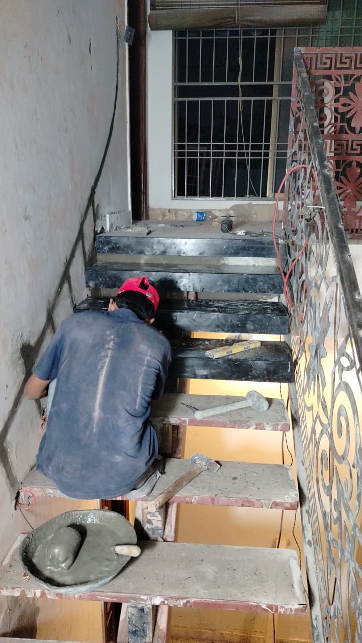 Black stone treads being fitted onto the staircase frame