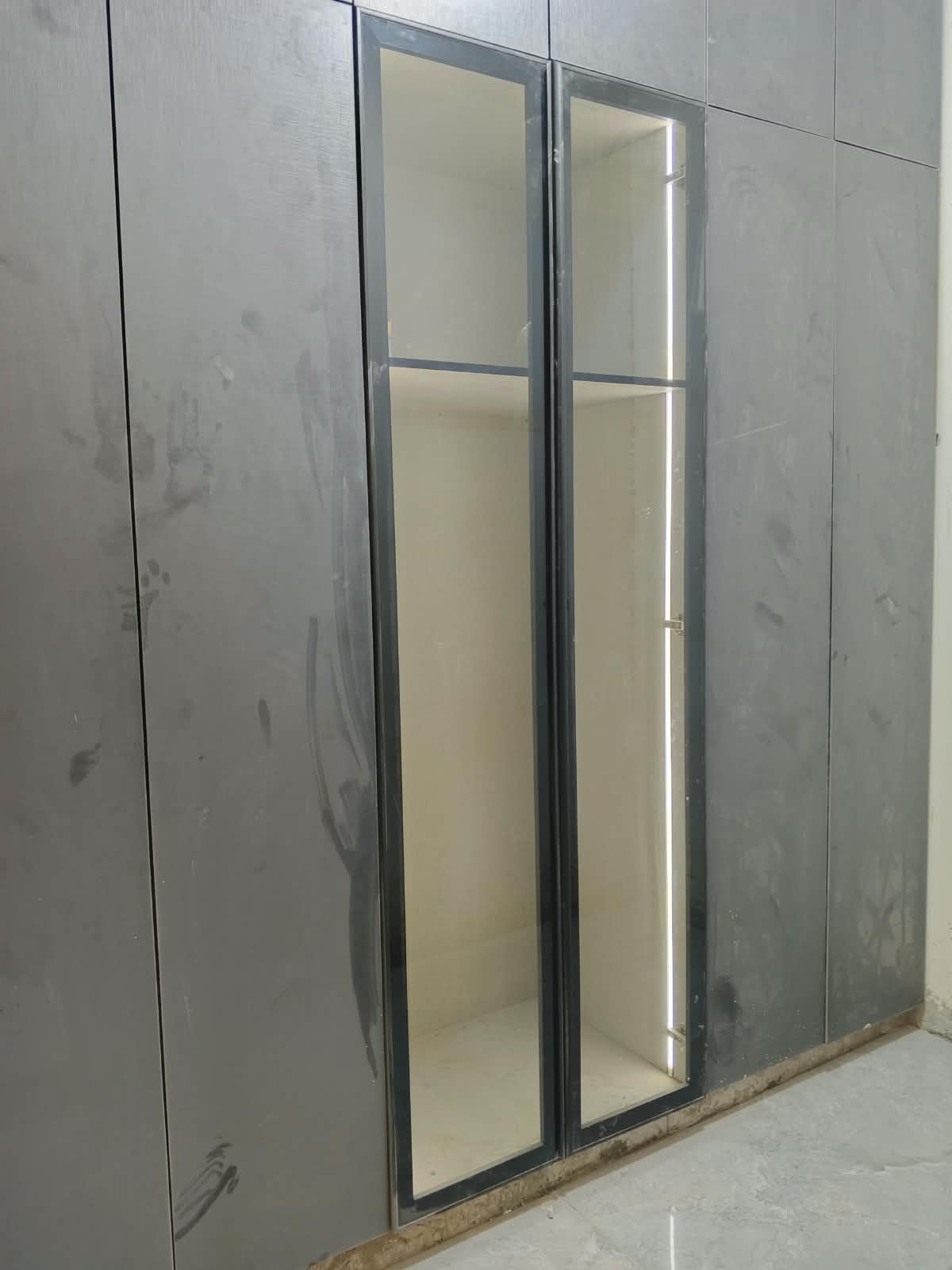 Wardrobe with glass-framed doors and built-in LED lighting