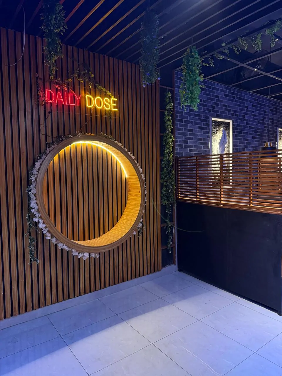 Circular timber feature wall with warm lighting and the Daily Dose neon sign