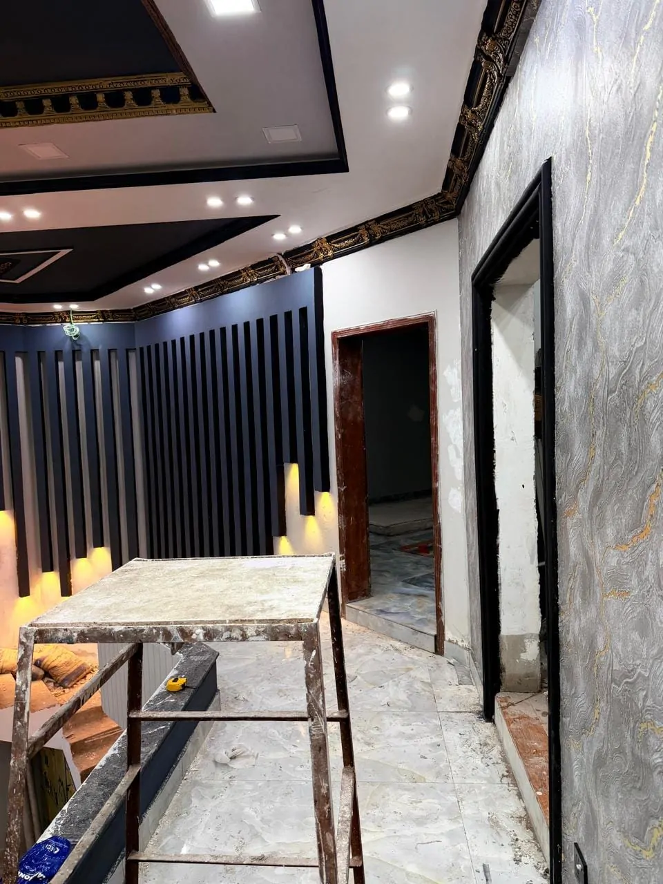 Upper landing nearing completion, with lit battens and a marble-effect wall finish