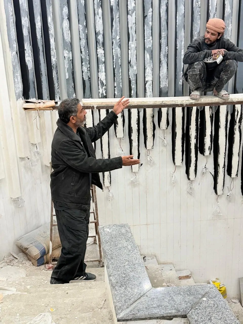 Site supervisor directing work on the staircase feature wall