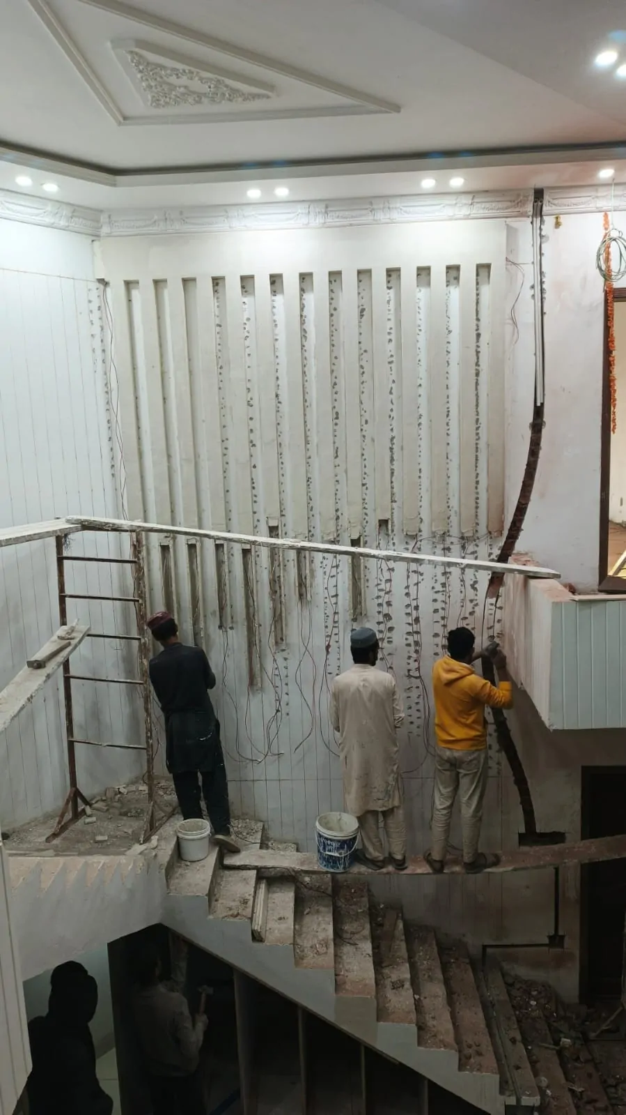 Site team fixing the wall battens and wiring for the staircase lighting