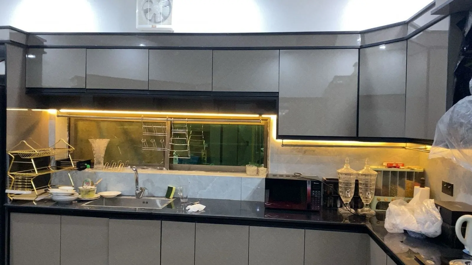 High-gloss kitchen with under-cabinet lighting and a black granite worktop