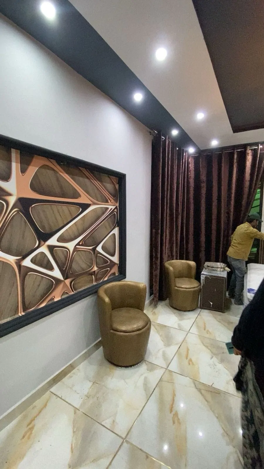 Seating corner with a framed 3D feature panel, velvet curtains and a marble-look floor