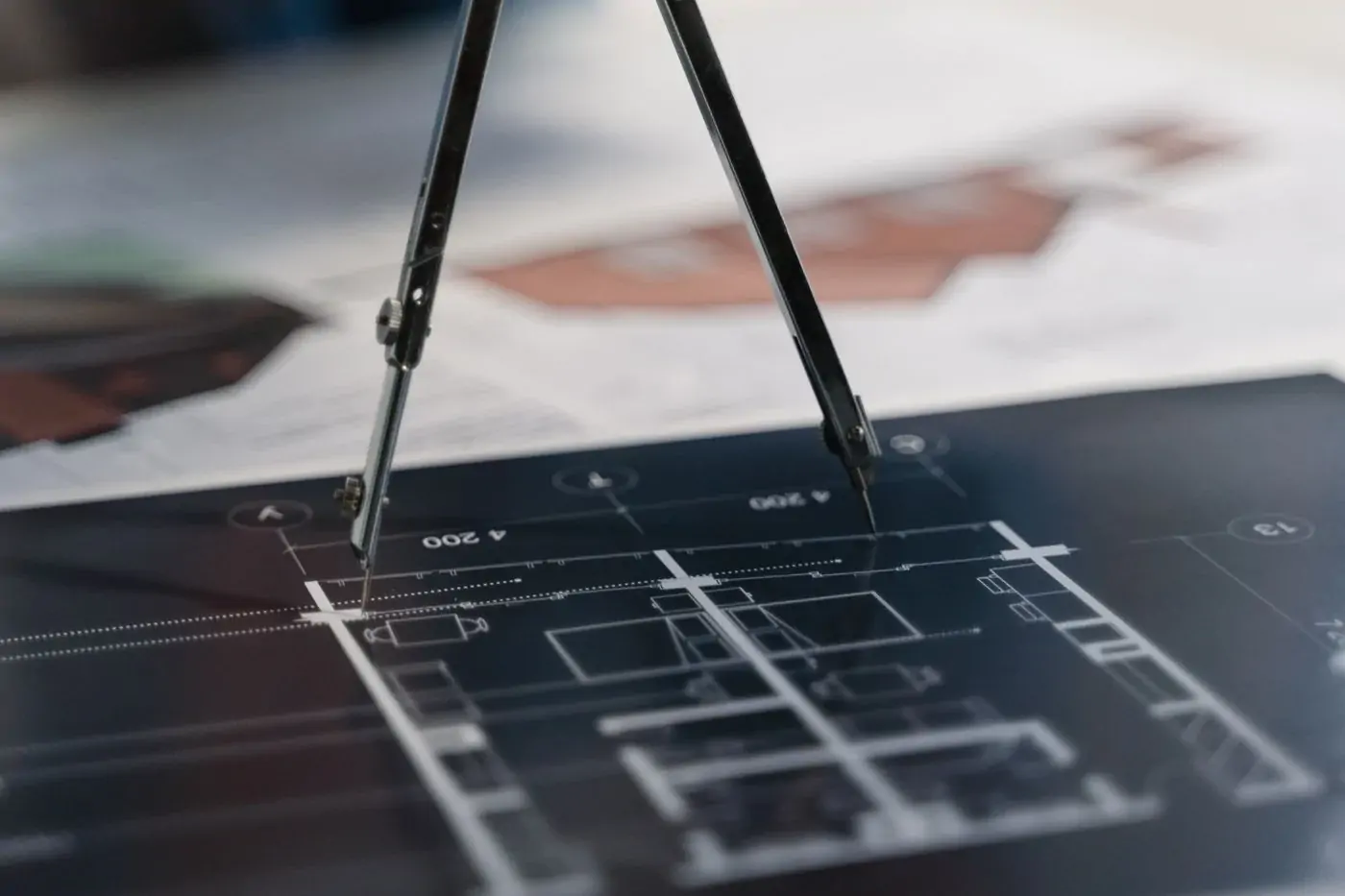 Drafting compass resting on architectural drawings