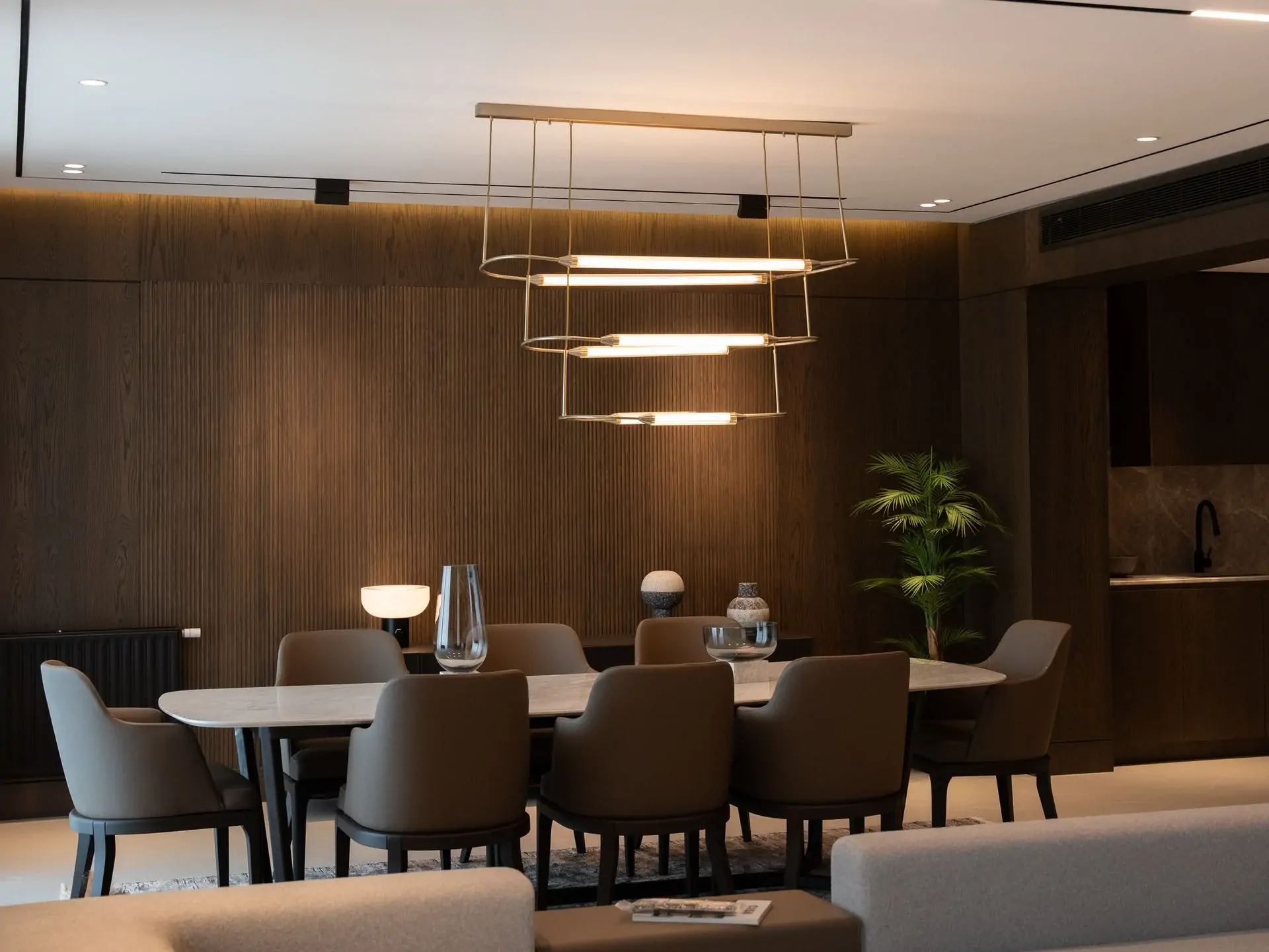 Dining room interior with a modern chandelier and dark finishes
