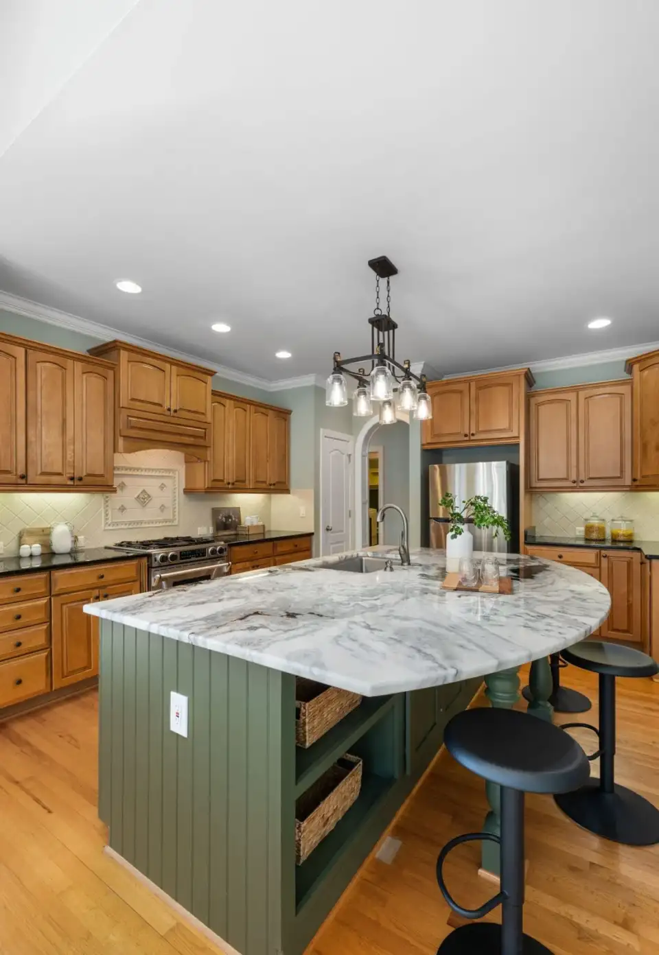 Modern residence kitchen with marble island and wooden cabinetry