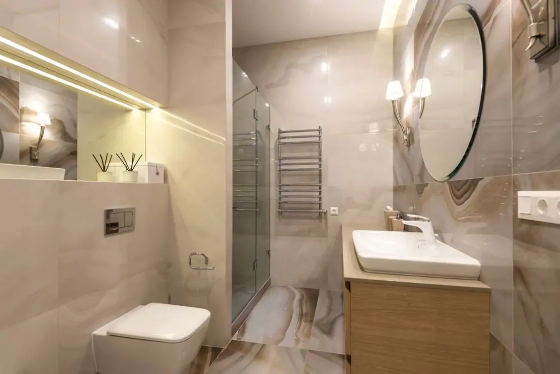 Private residence bathroom with marble tiles and large mirror