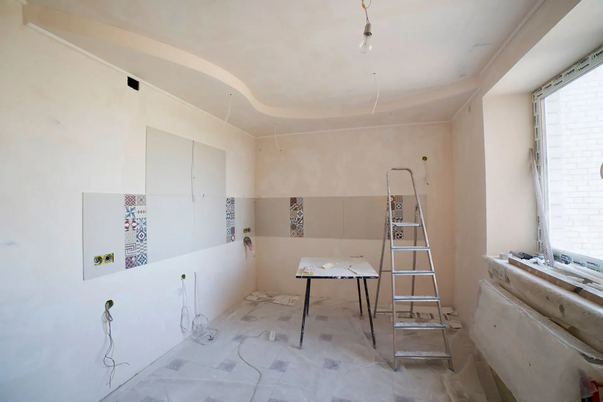 Kitchen under renovation with ladder and tools